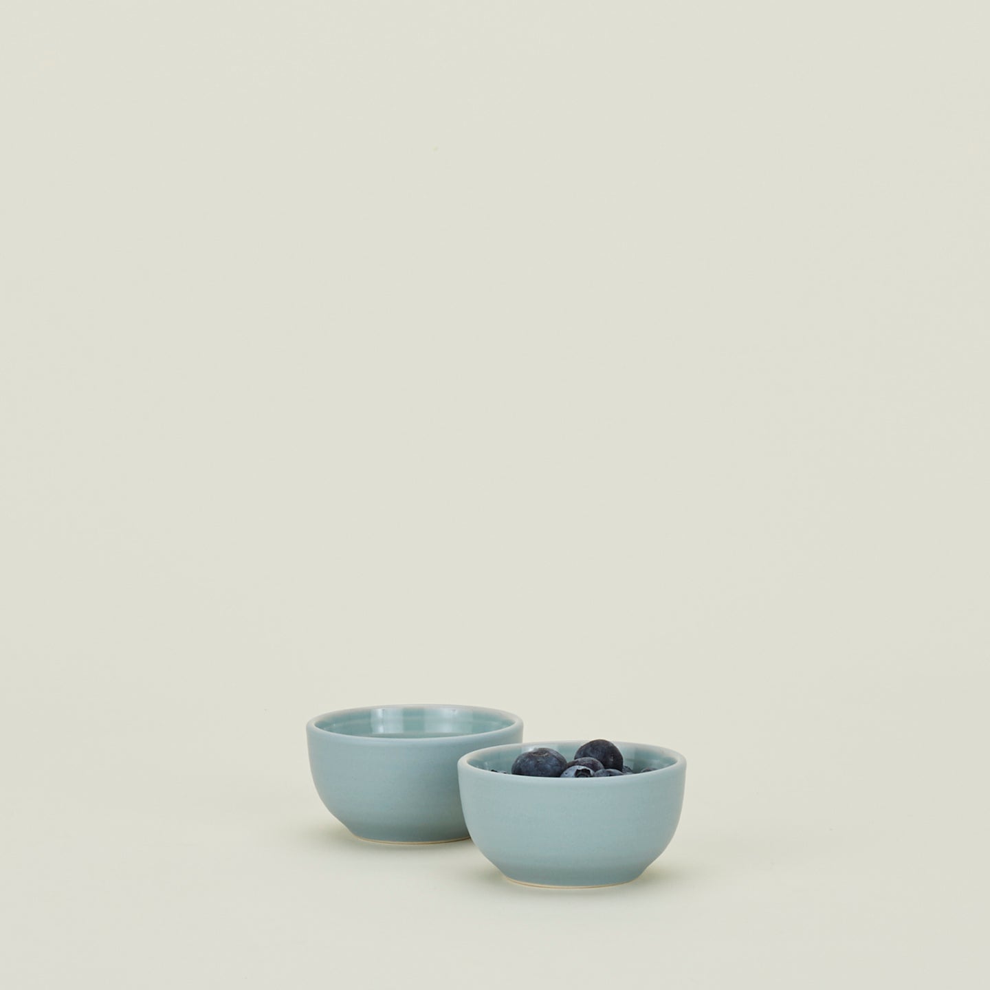 Two Essential Extra Small Bowls in Sky filled with blueberries.