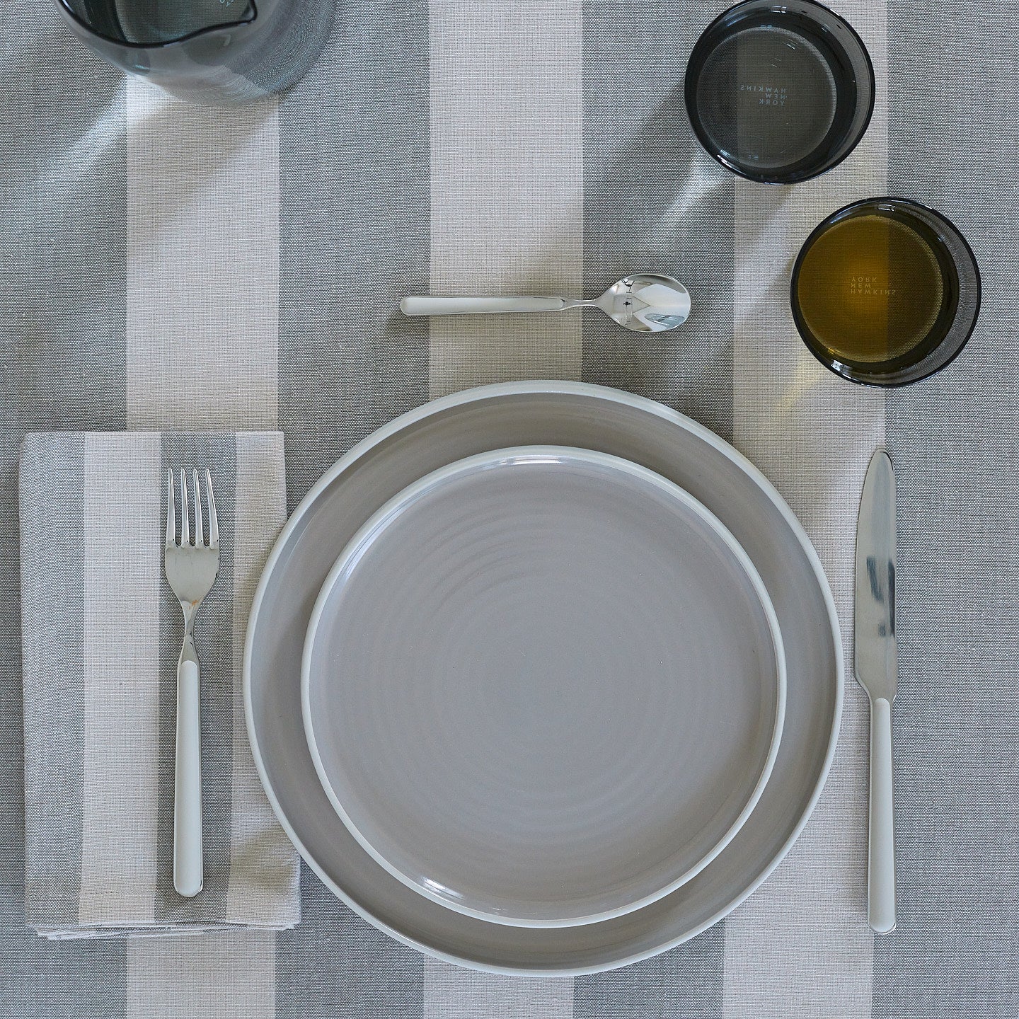 Placesetting on Essential Striped Tablecloth in Light Grey and Dark Grey.