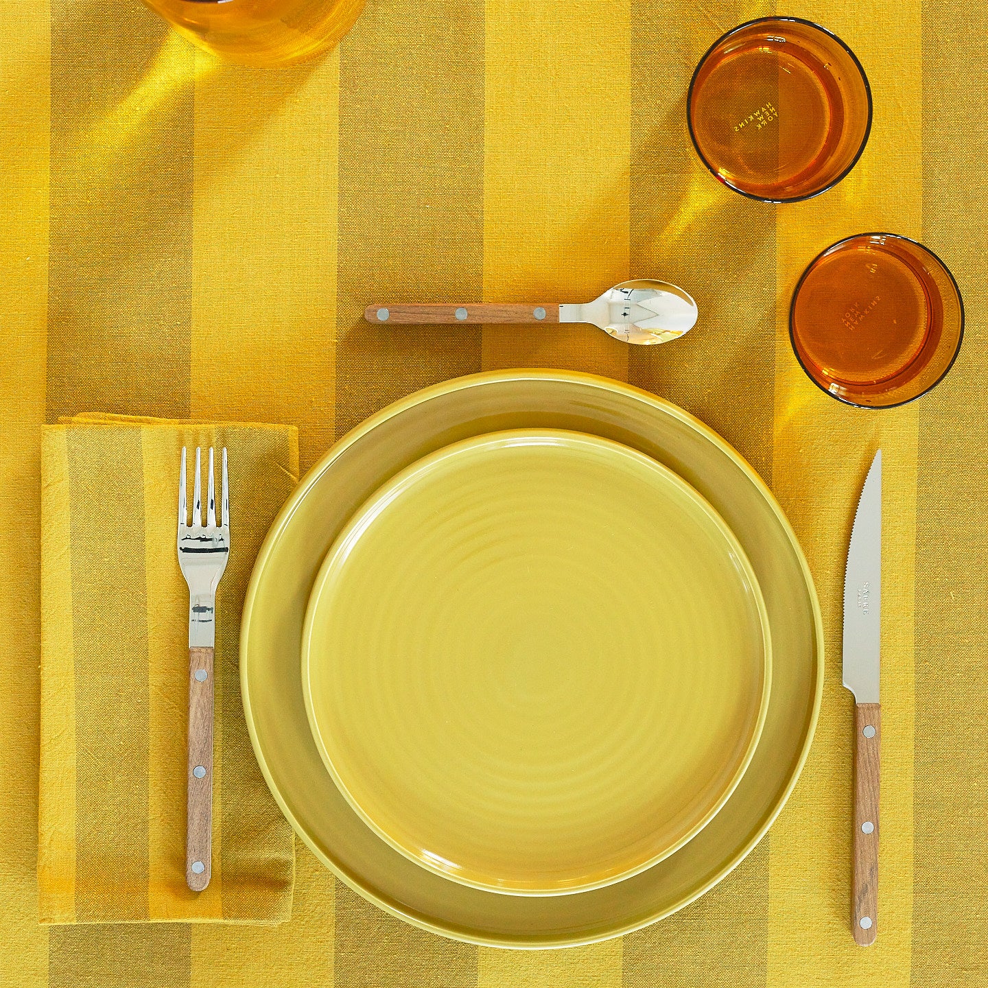 Placesetting on Essential Striped Tablecloth in Mustard and Bronze.