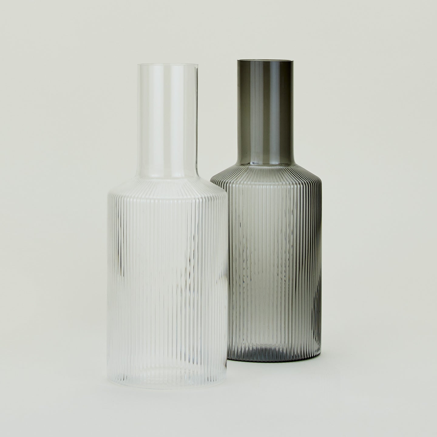 Two Ripple Carafes, one in Grey and one in Clear.