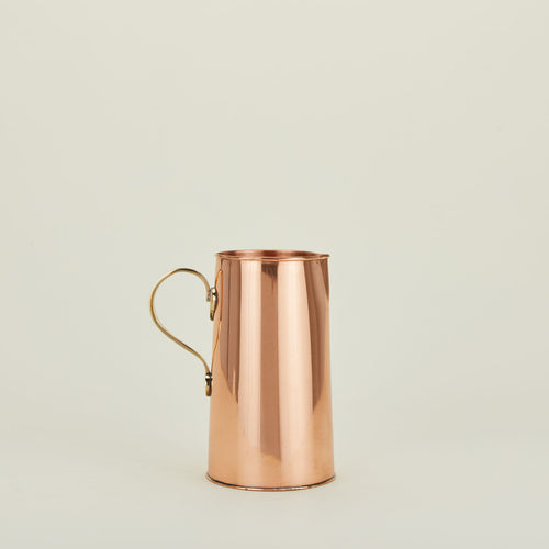 Copper water pitcher with brass handle.