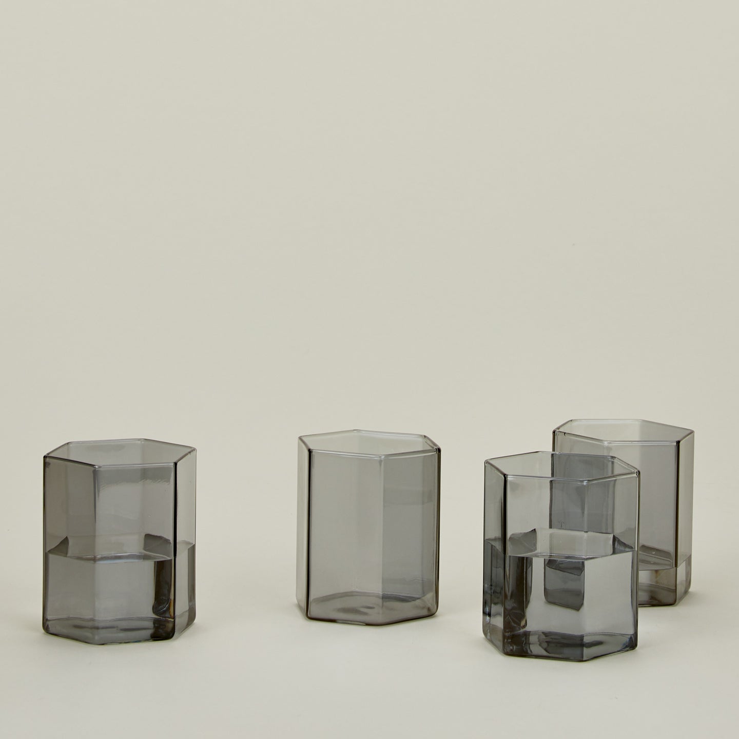 Set of 4 small Helix Glasses in Grey with water.