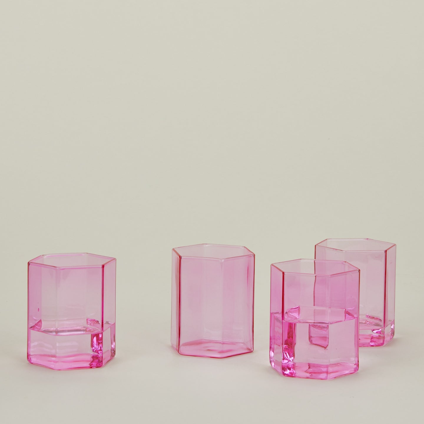 Set of 4 small Helix Glasses in Pink with water.