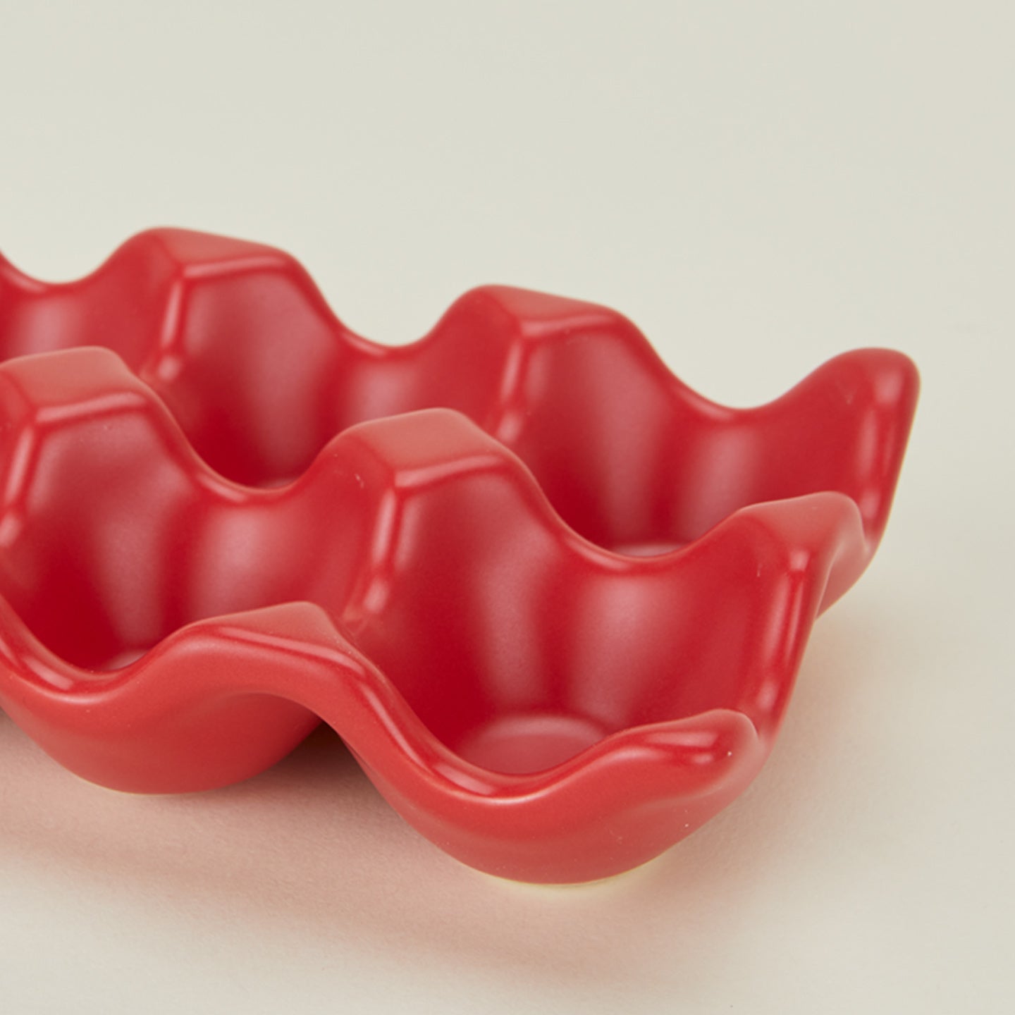 Detail view of ceramic half dozen egg holder in red