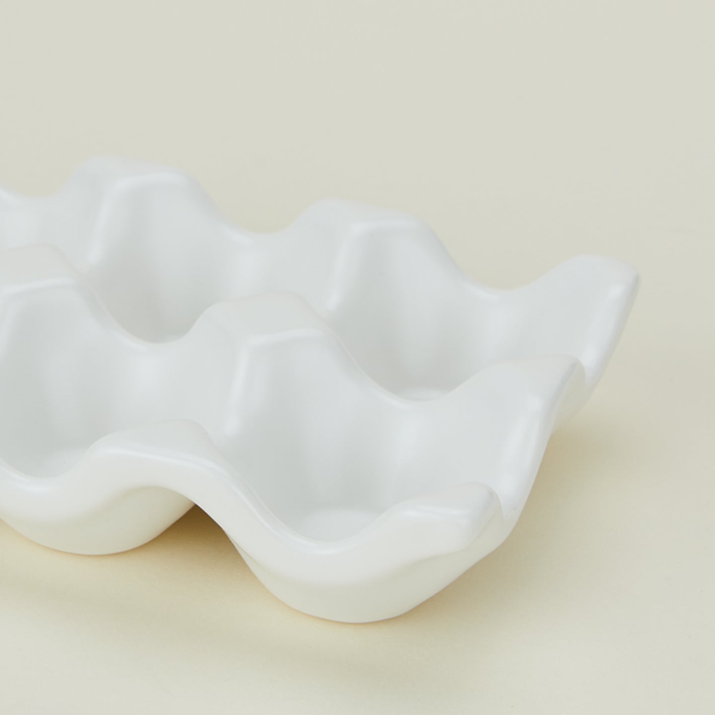 Detail view of ceramic half dozen egg holder in white