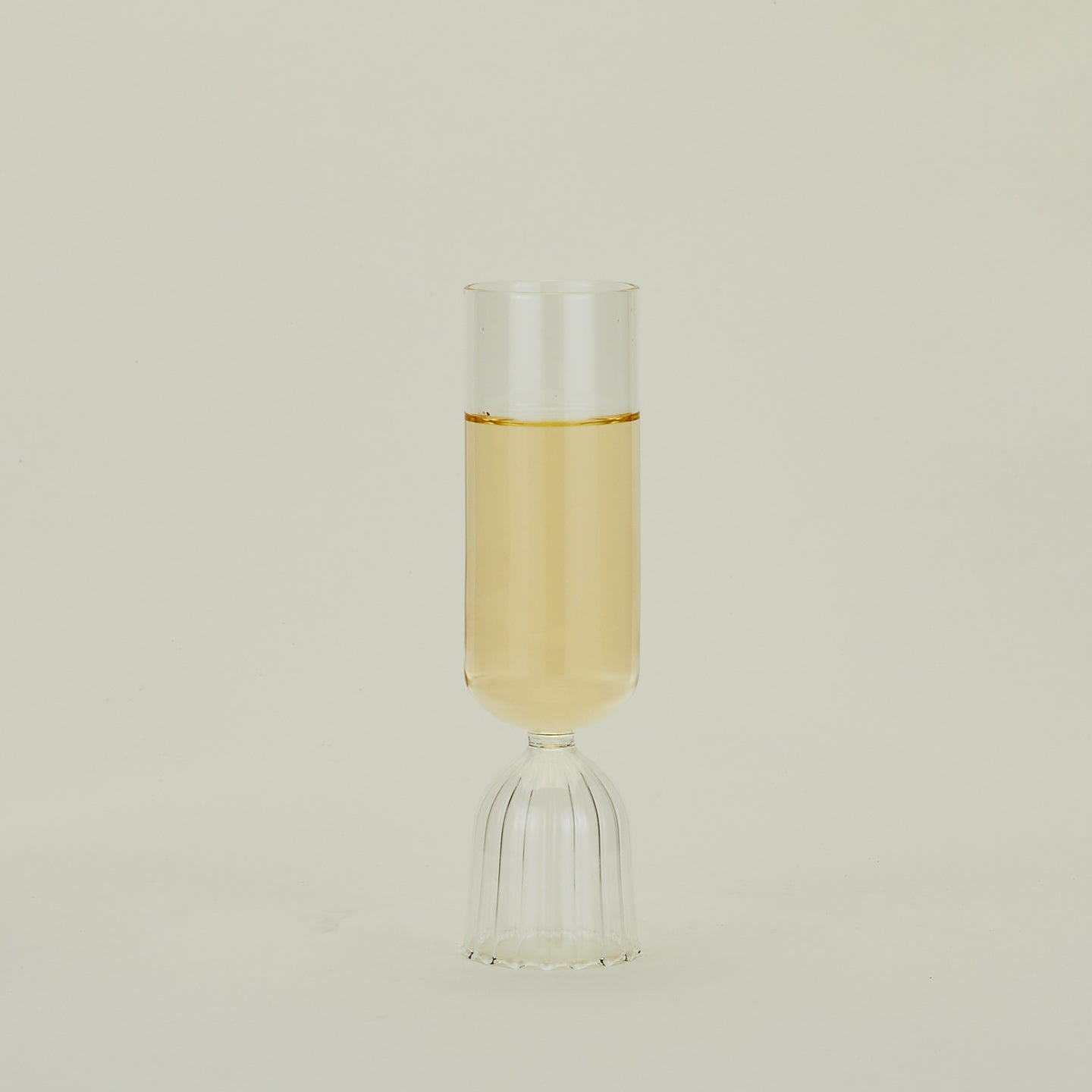 Flute glass with clear stem and clear cup, filled with sparkling wine.