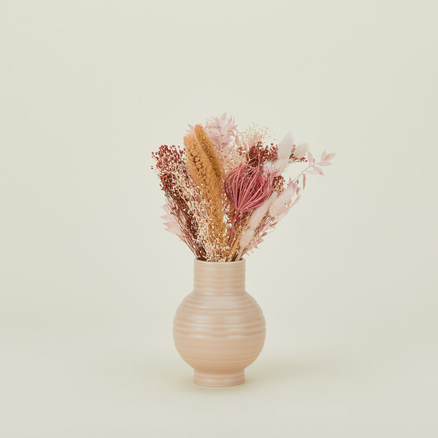 Dried floral bouquet in pink and coral in a vase.