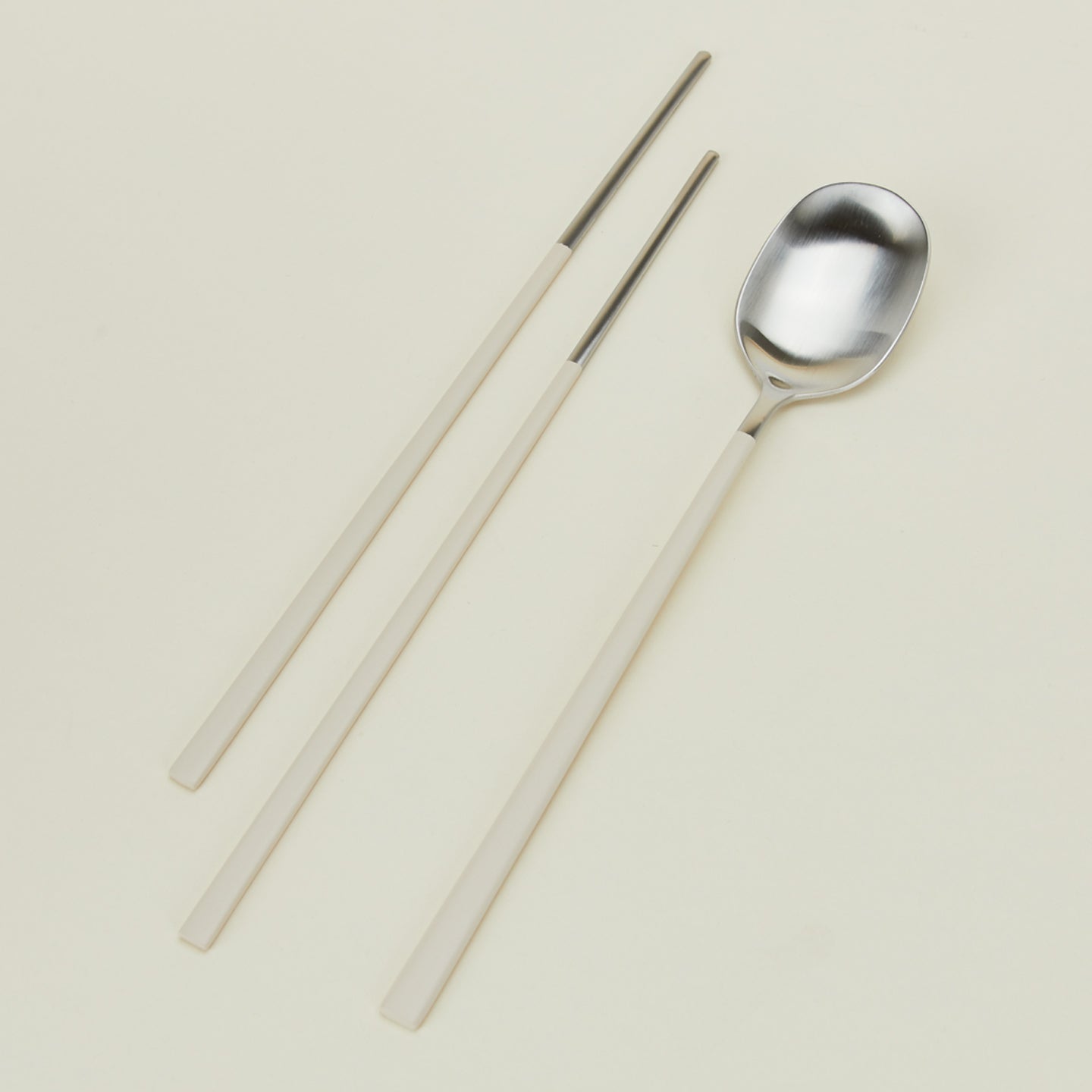 Close up view of Illo spoon and chopstick set in almond