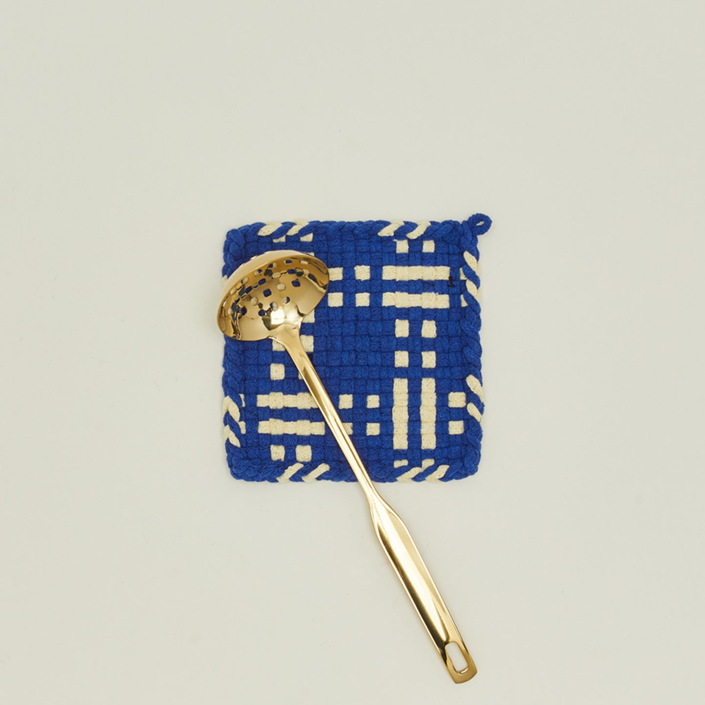 Dots and dashes potholder in blue and yellow with brass ladle