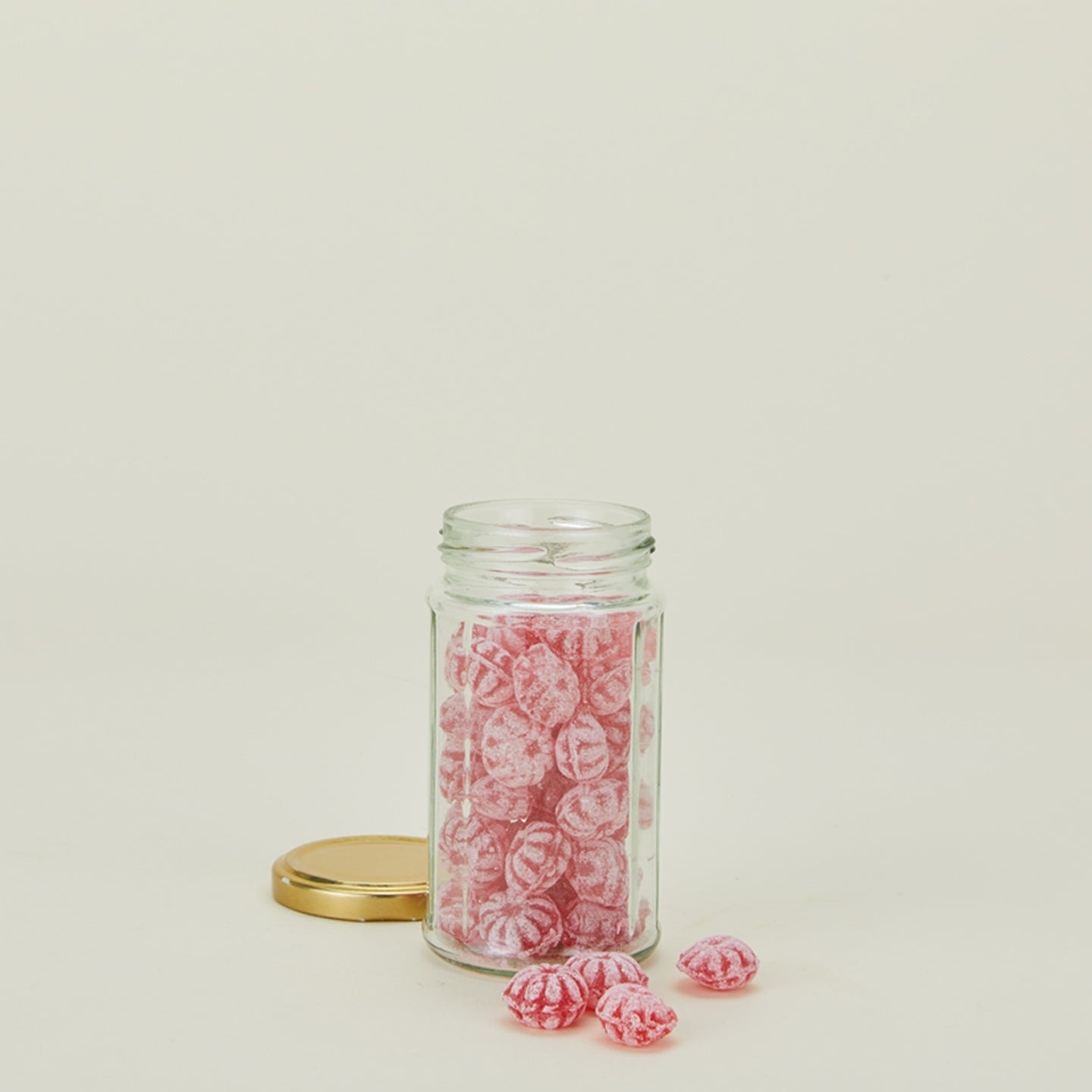 Traditional raspberry candies in glass jar with lid off