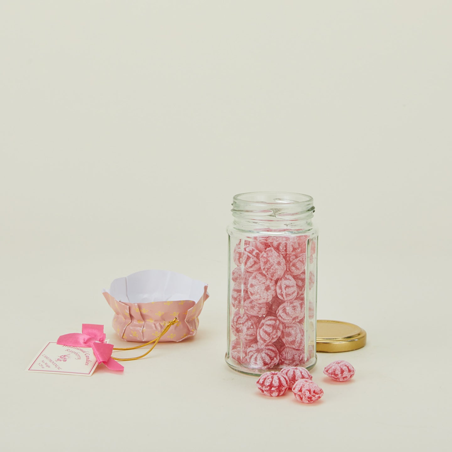 Traditional raspberry candies in glass jar with lid off