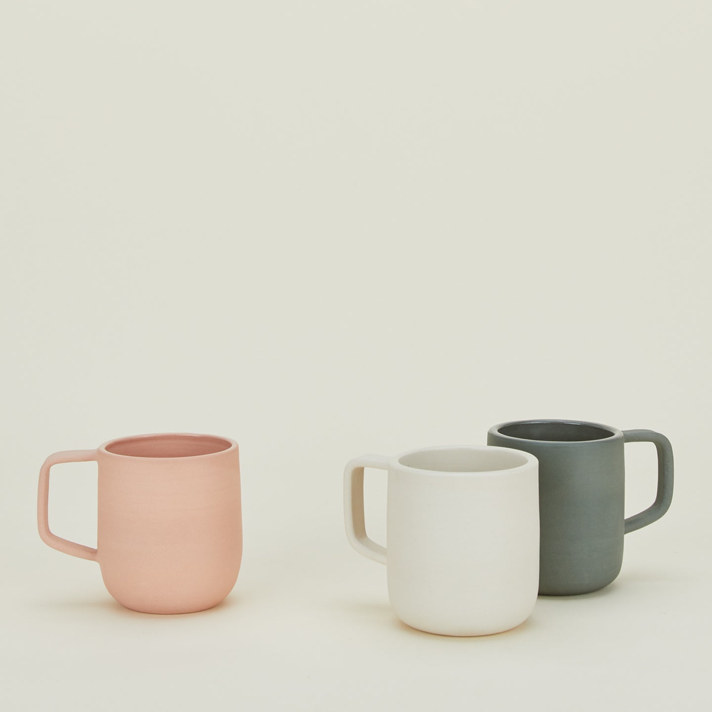 Group of Stoneware Pigment Mugs in various colors.