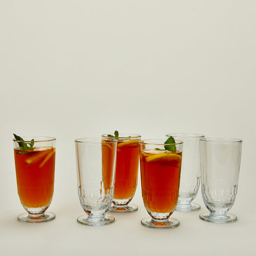 Six Artois Ice Tea glasses, some with ice tea.