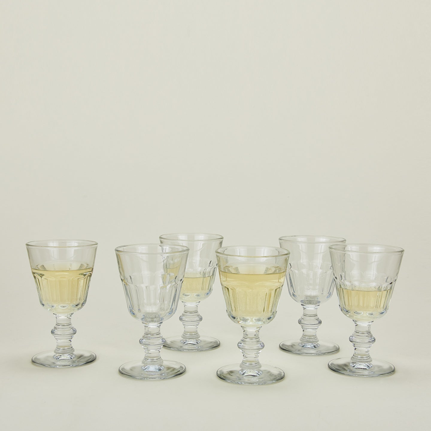 Six Perigord wine glasses, some with wine.