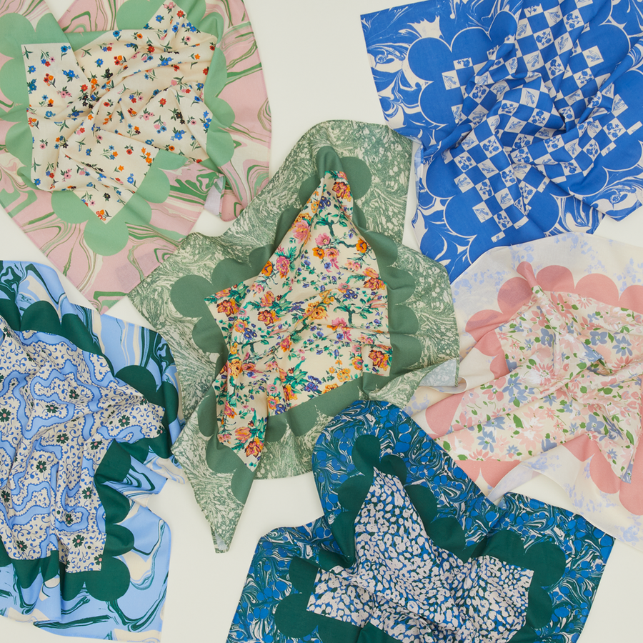 An overhead view of an assortment of floral patterned napkins in a variety of colors.