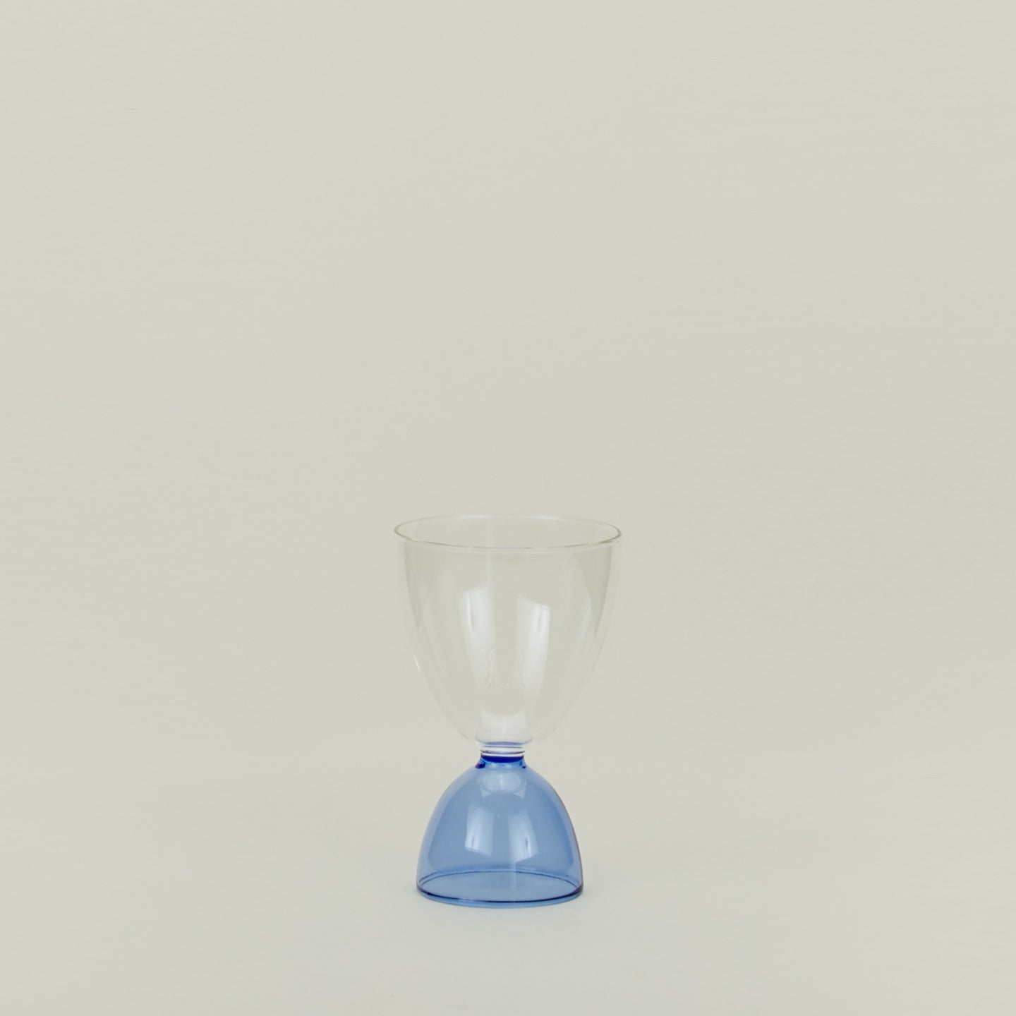 Tumbler glass with blue stem and clear cup.