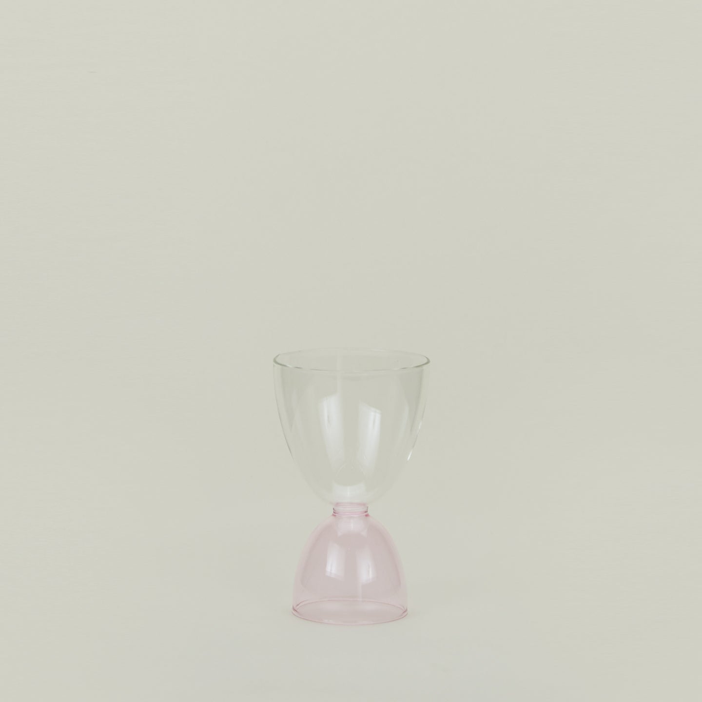 Tumbler glass with blush stem and clear cup.