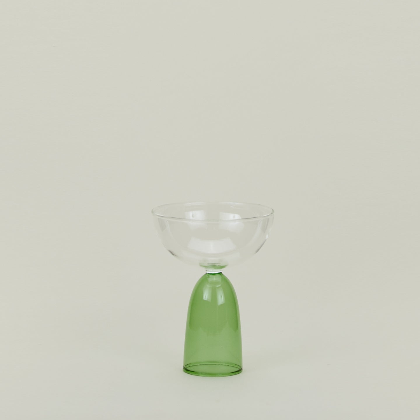 Coupe glass with green stem and clear cup.