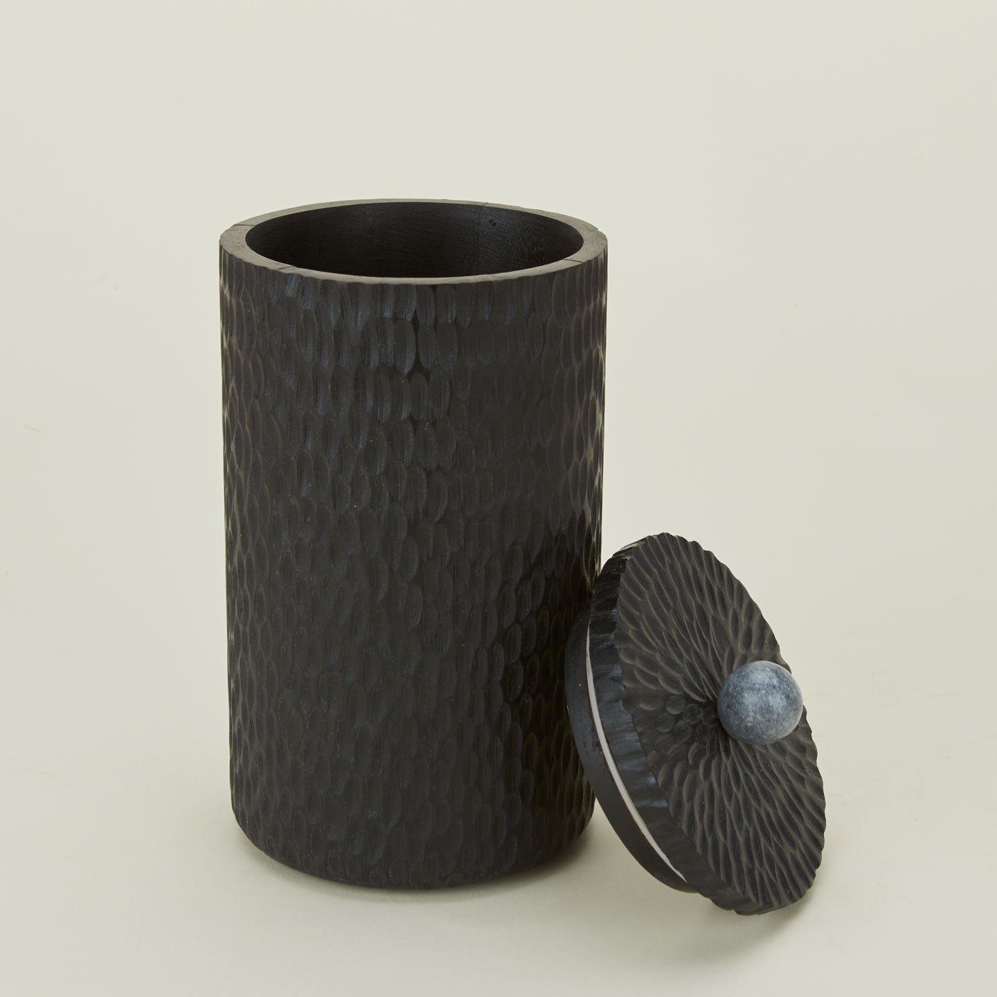 Close up of large black Camelia wood lidded canister with marble knob.