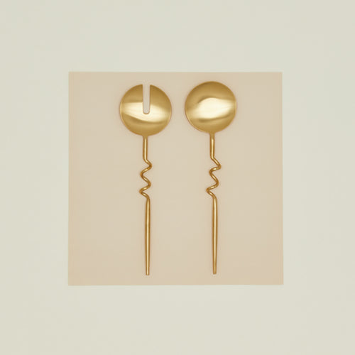 Set of two Elisa brass servers on paper background.