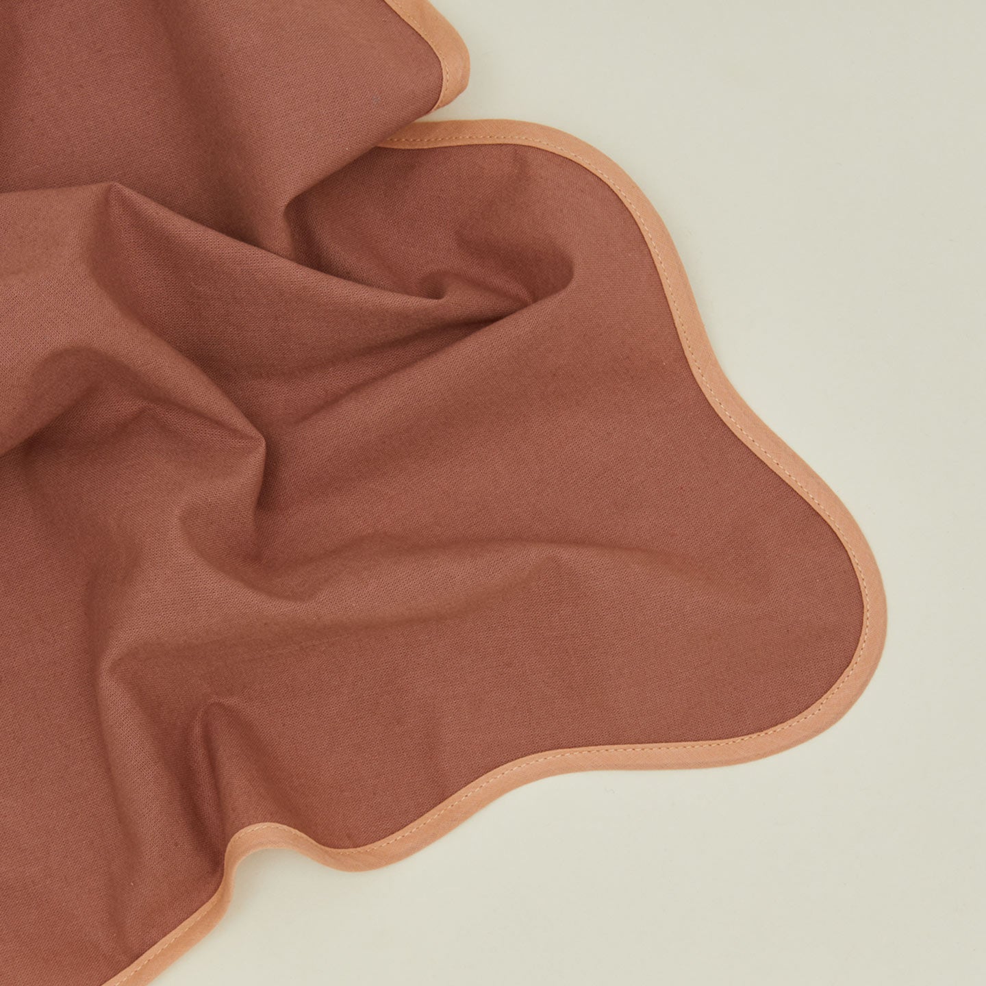 Detailed view of cocoa scalloped napkin