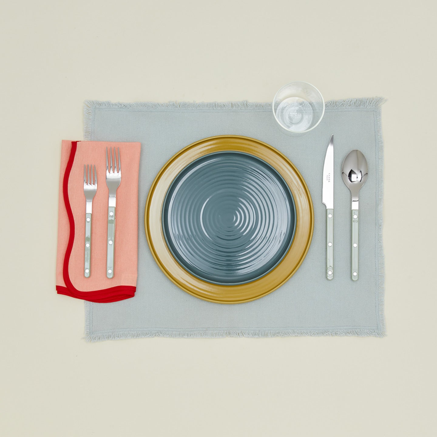 Modafleur scalloped napkin in tomato with place setting on placemat