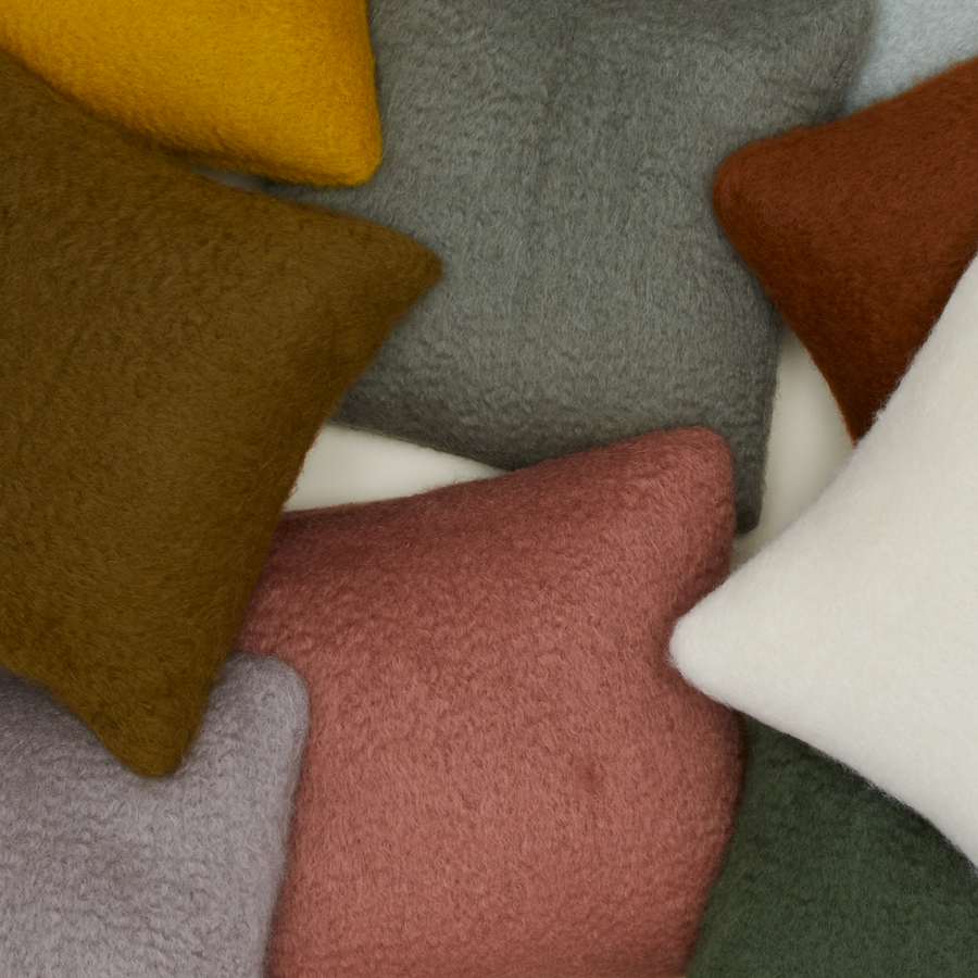 A pile of mohair pillows in various colors.