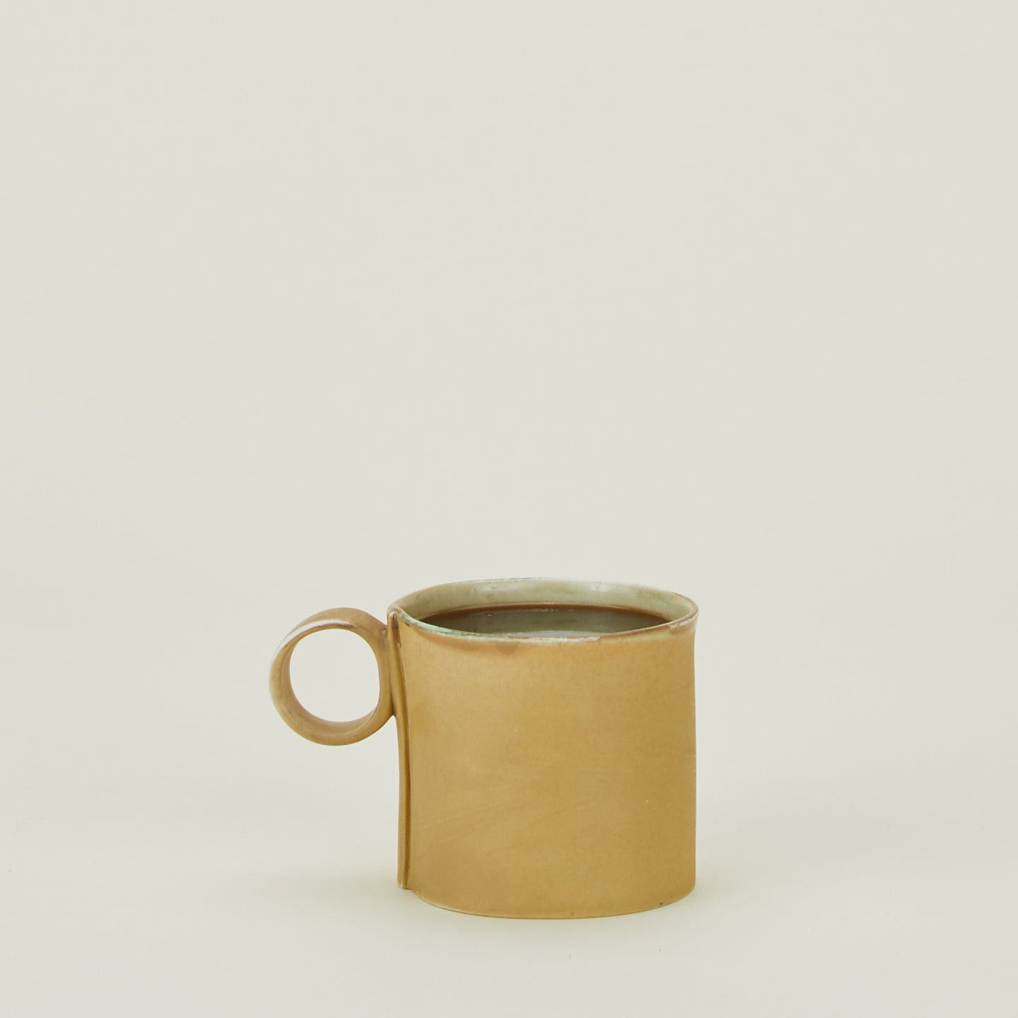 Loop Handled Mug in Ochre Gold, with coffee.