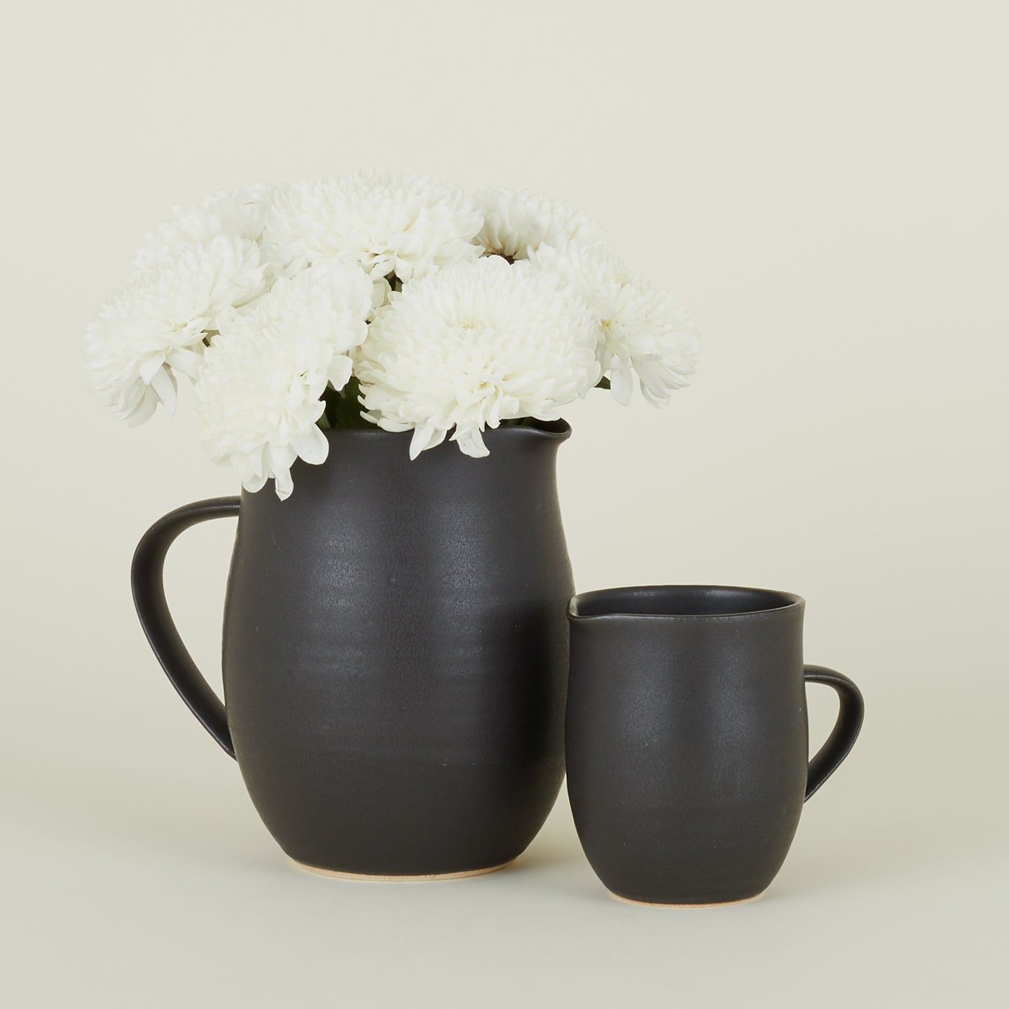 Stoneware Creamer and Stoneware Pitcher in Black with flowers.
