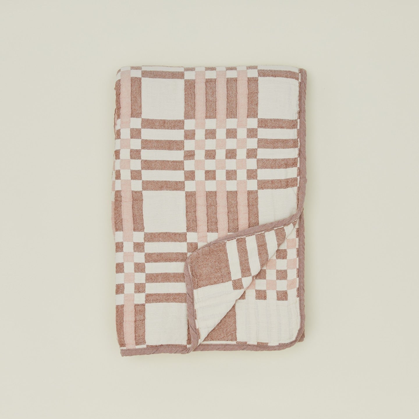 Overhead view of folded Simple Plaid Blanket in Blush and Terracotta.