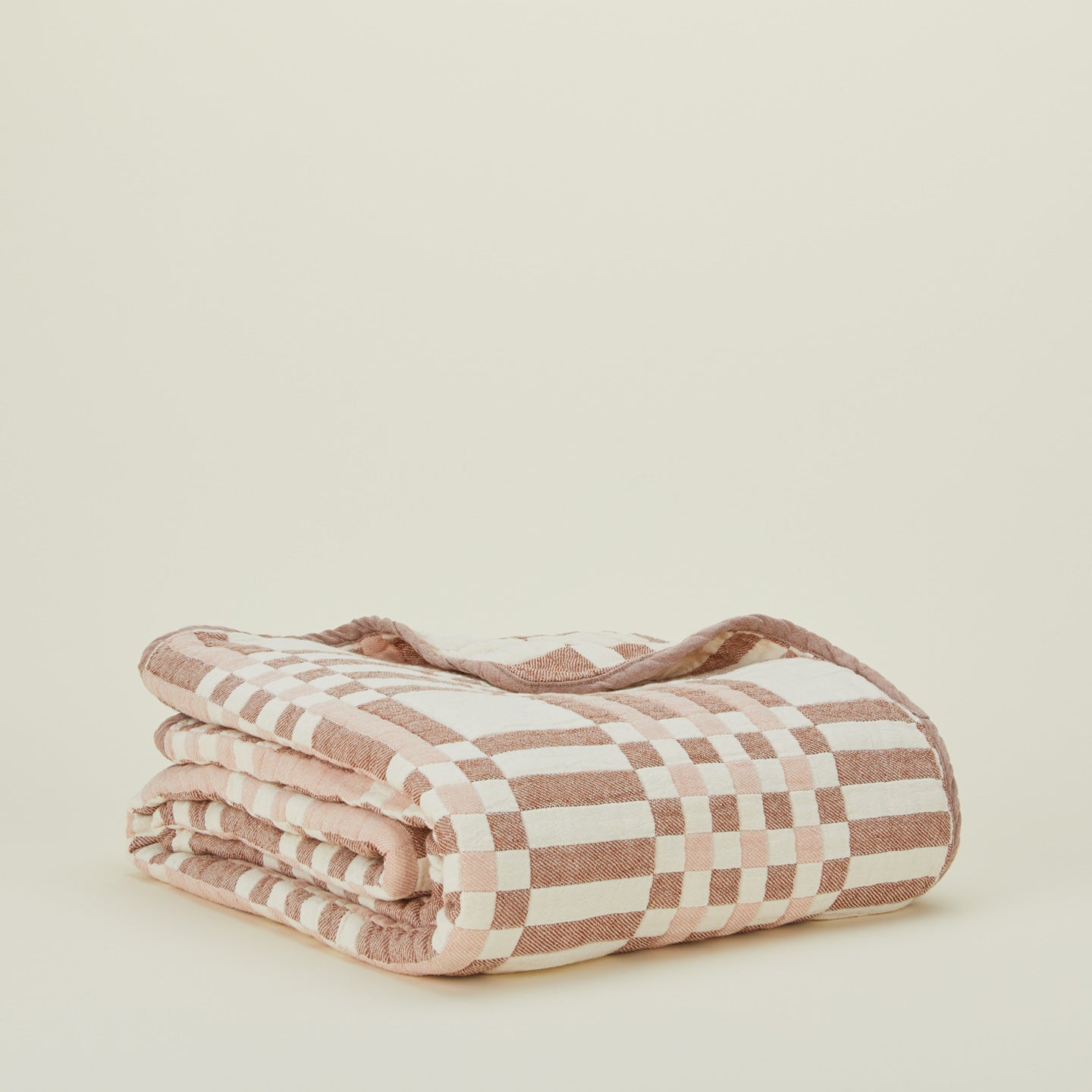 Side view of folded Simple Plaid Blanket in Blush and Terracotta.