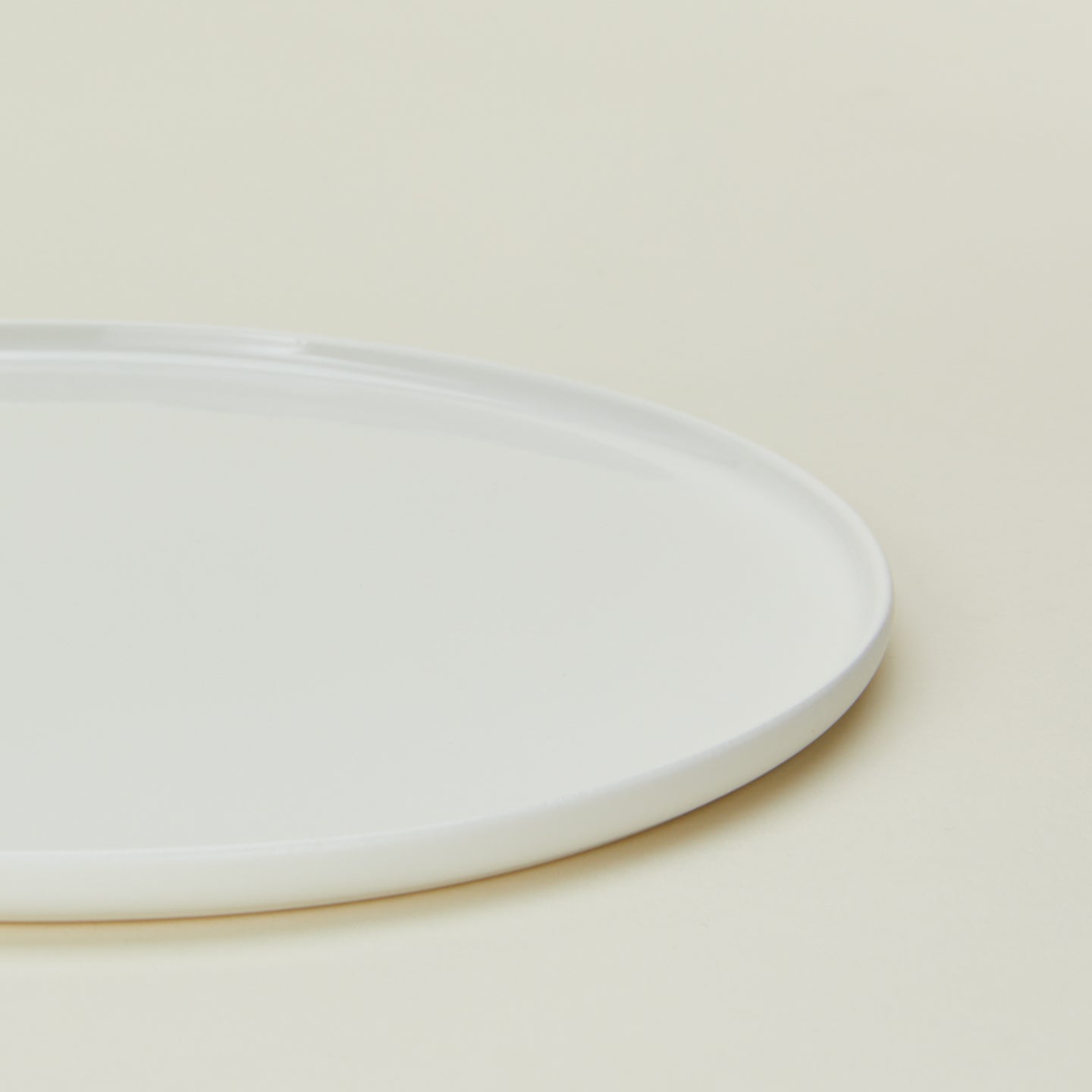 Close up view of simple porcelain dinnerplate in white.