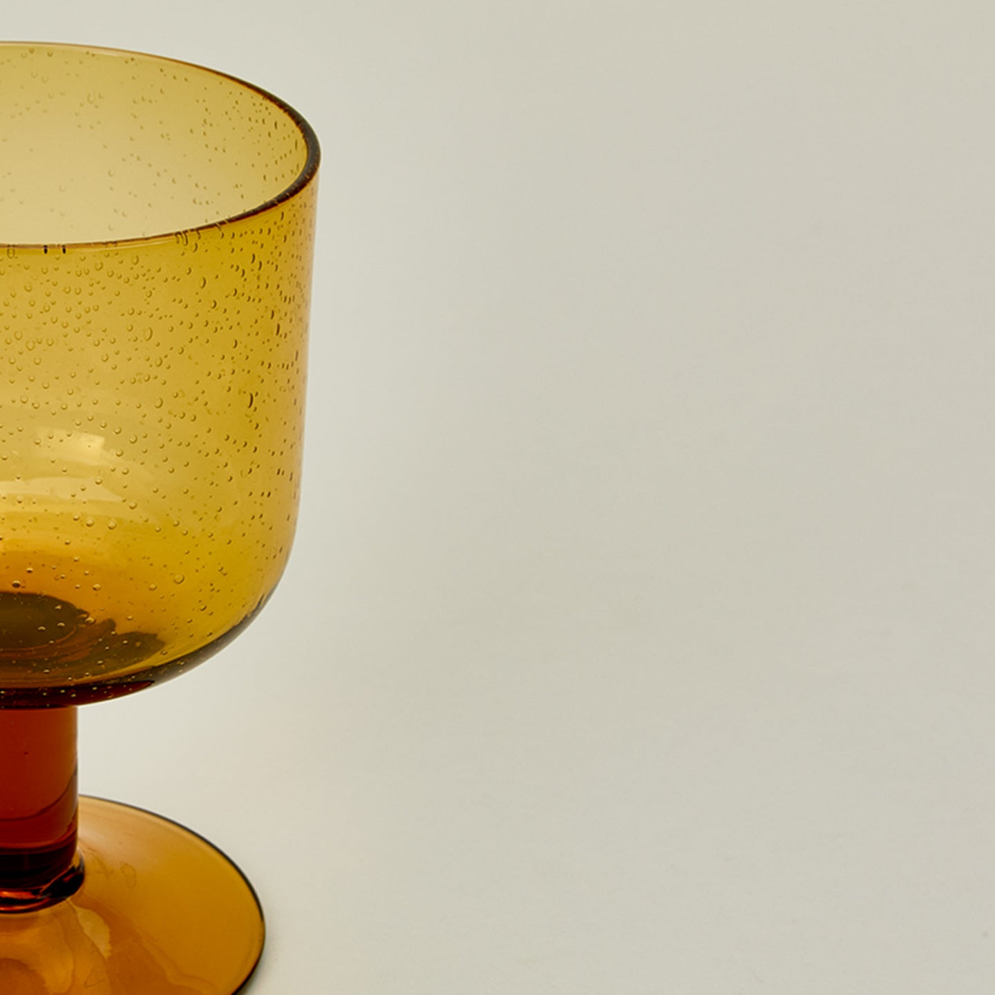 Detailed view of simple seeded glassware in amber.