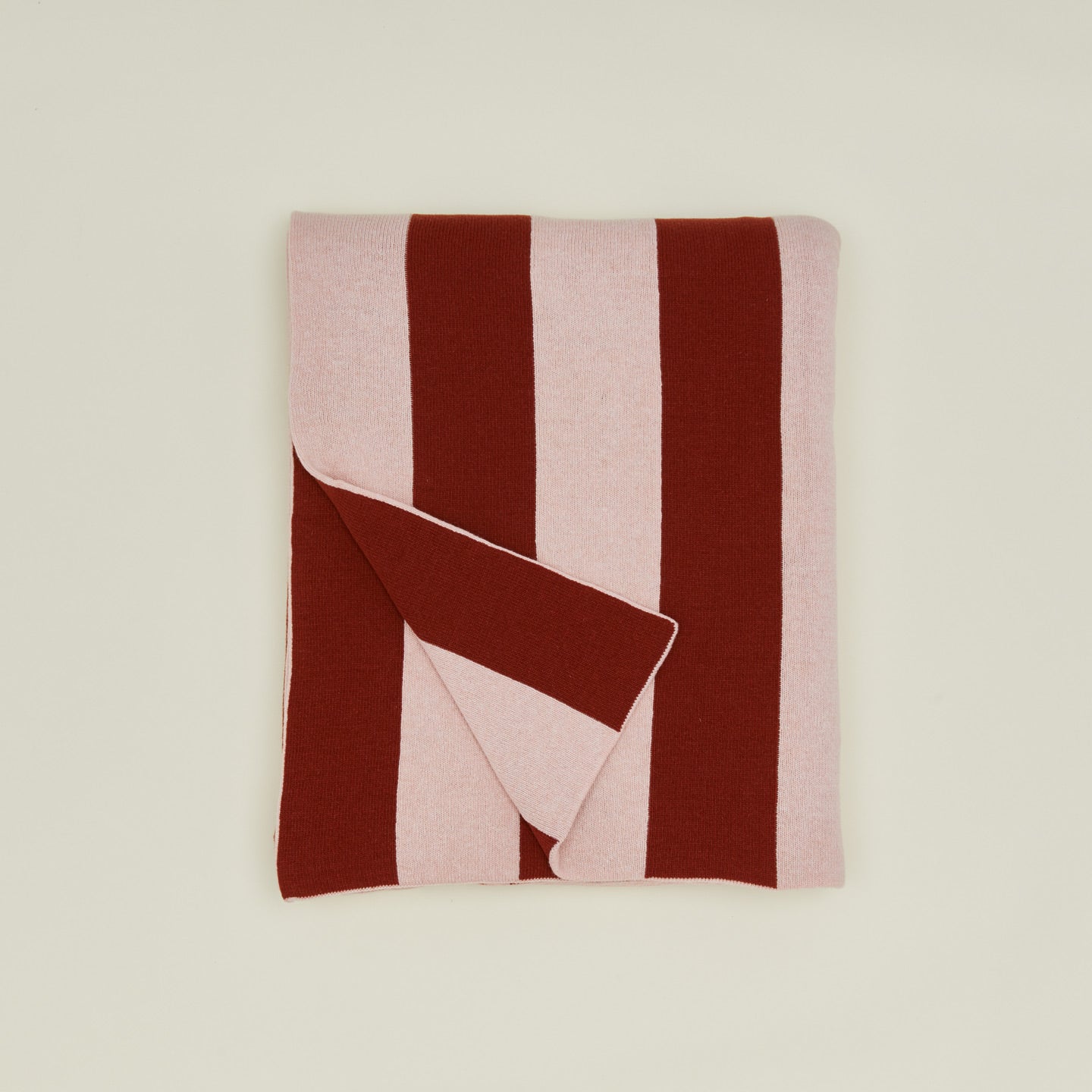 Folded blush and terracotta striped throw