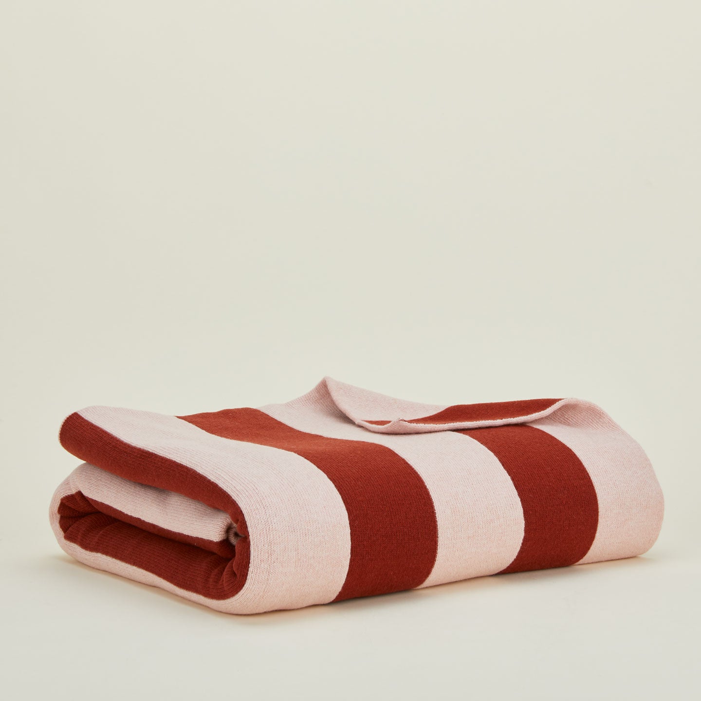 Folded blush and terracotta striped throw