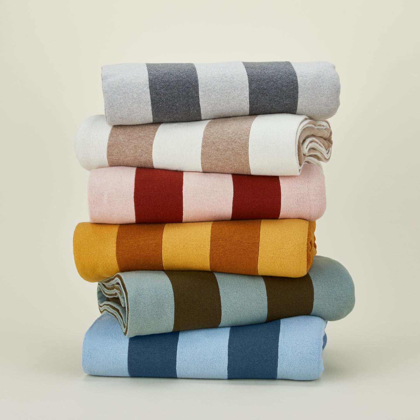 Stack of simple striped throws in various colors