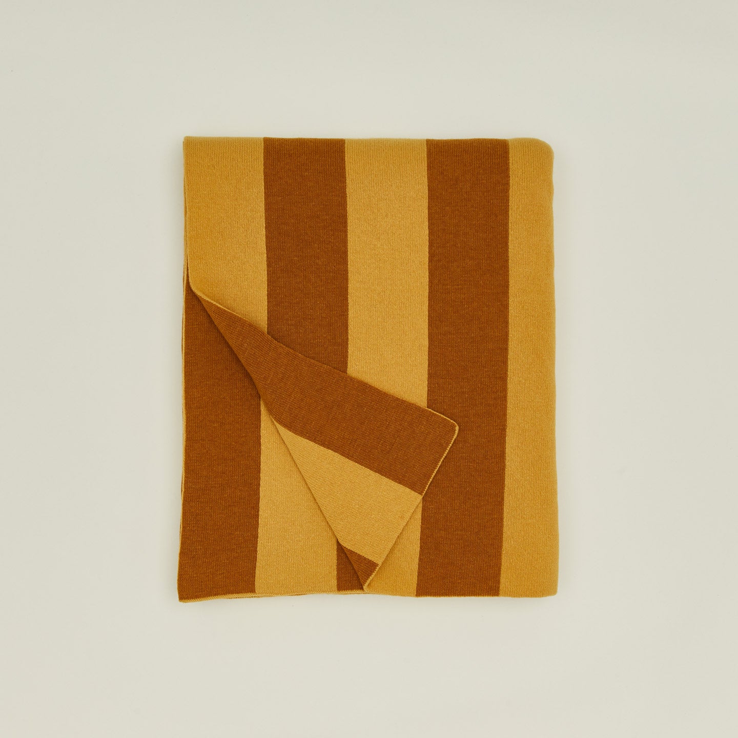 Folded simple striped throw in mustard and bronze