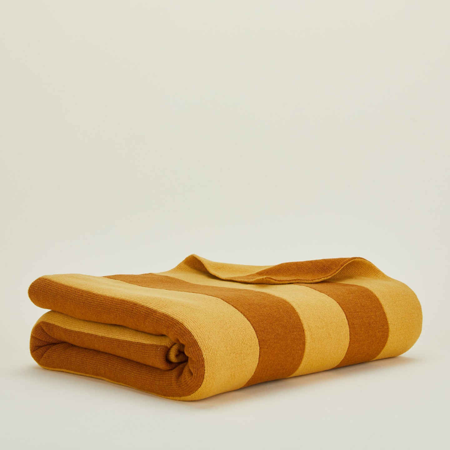 Folded simple striped throw in mustard and bronze