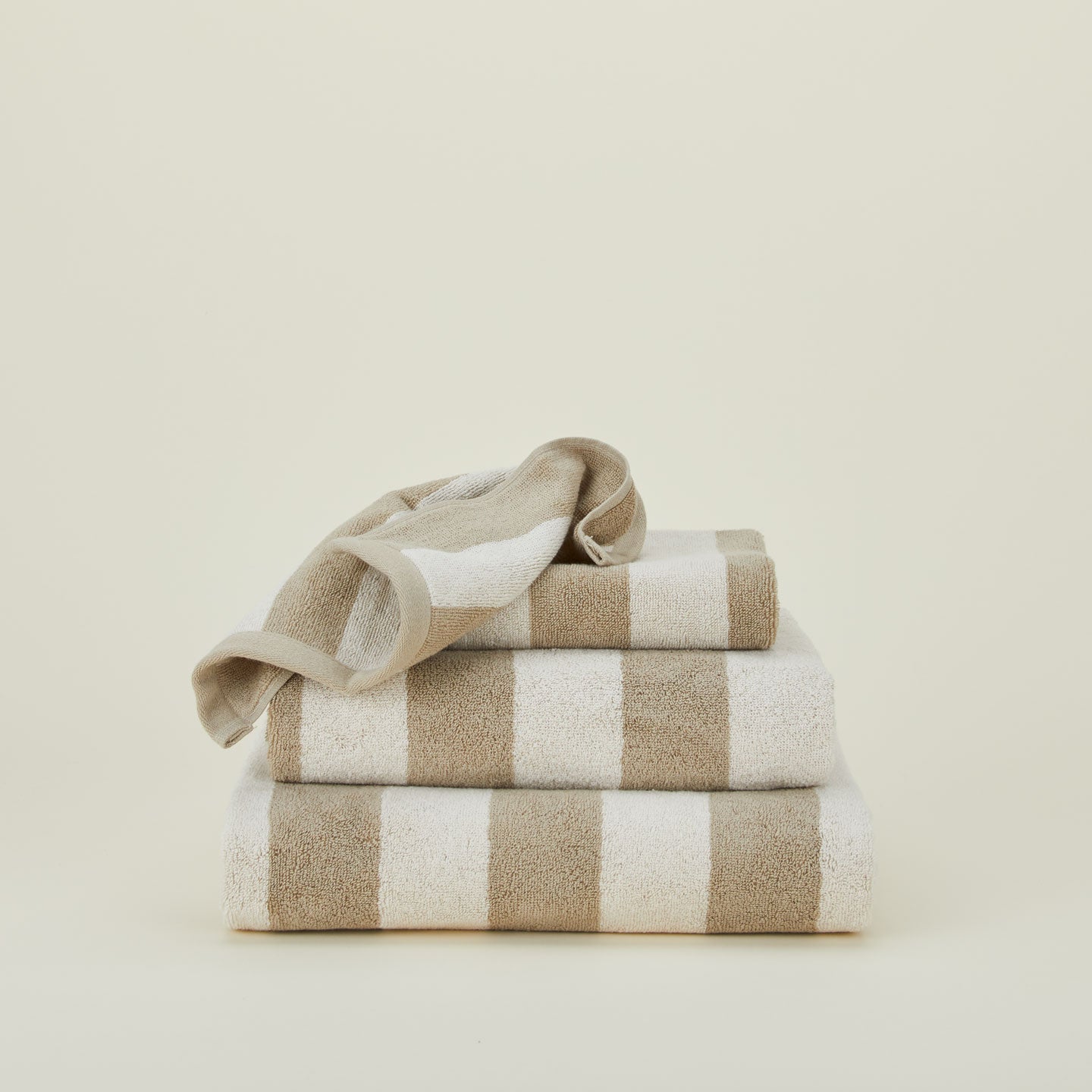 A stack of striped olive and sage terry towels in various sizes.