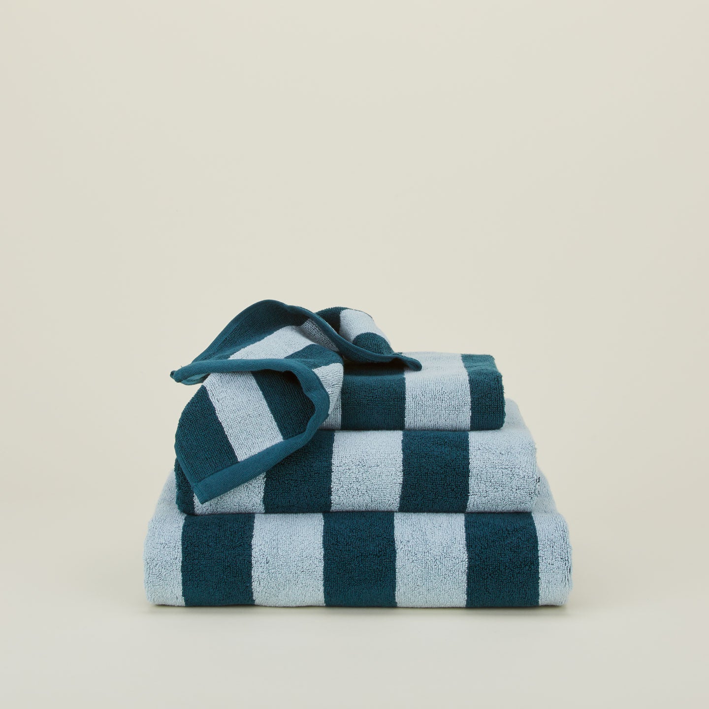 A stack of striped olive and sage terry towels in various sizes.