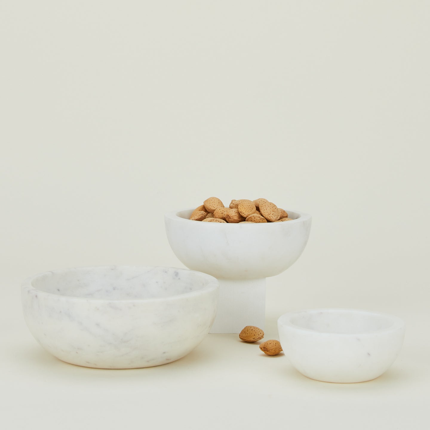 Three Simple Marble Bowls in various sizes in White, with nuts.