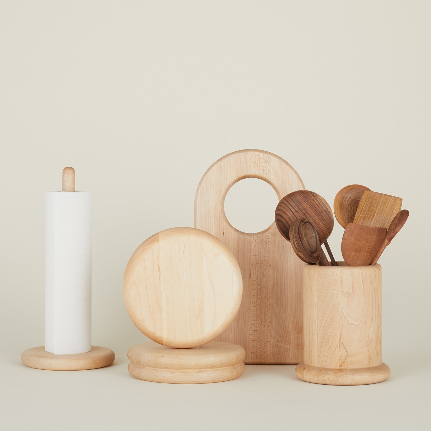 Simple wood collection with paper towel holder cutting boards and utility crock filled with wooden utensils