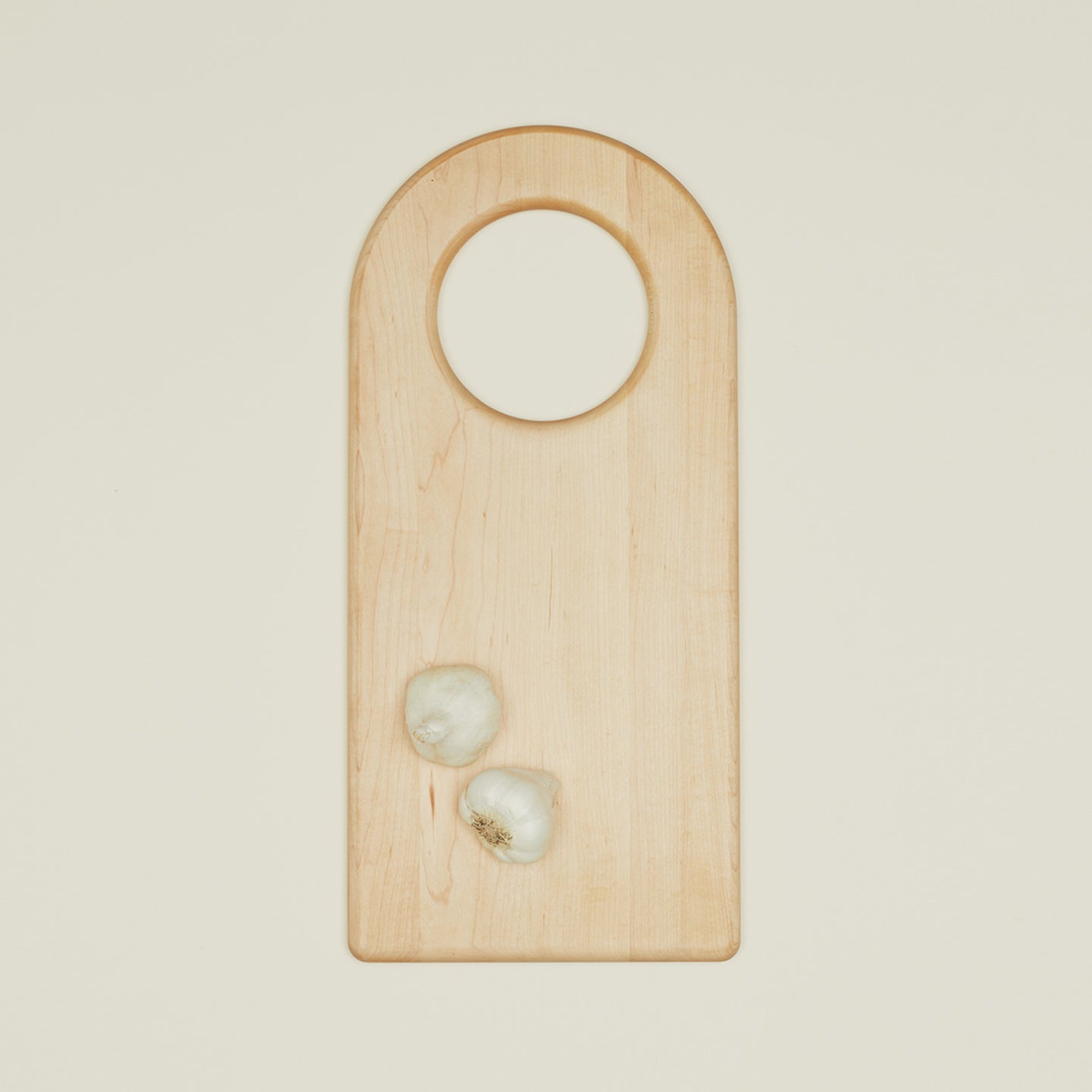 Large arched cutting board with two garlic cloves