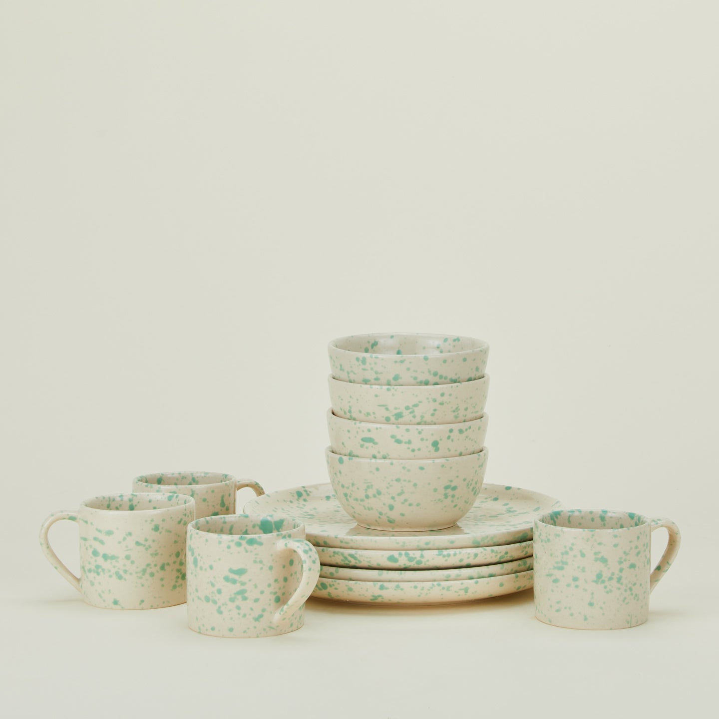 Set of four Splatterware plates, bowls, and mugs in Nettle.