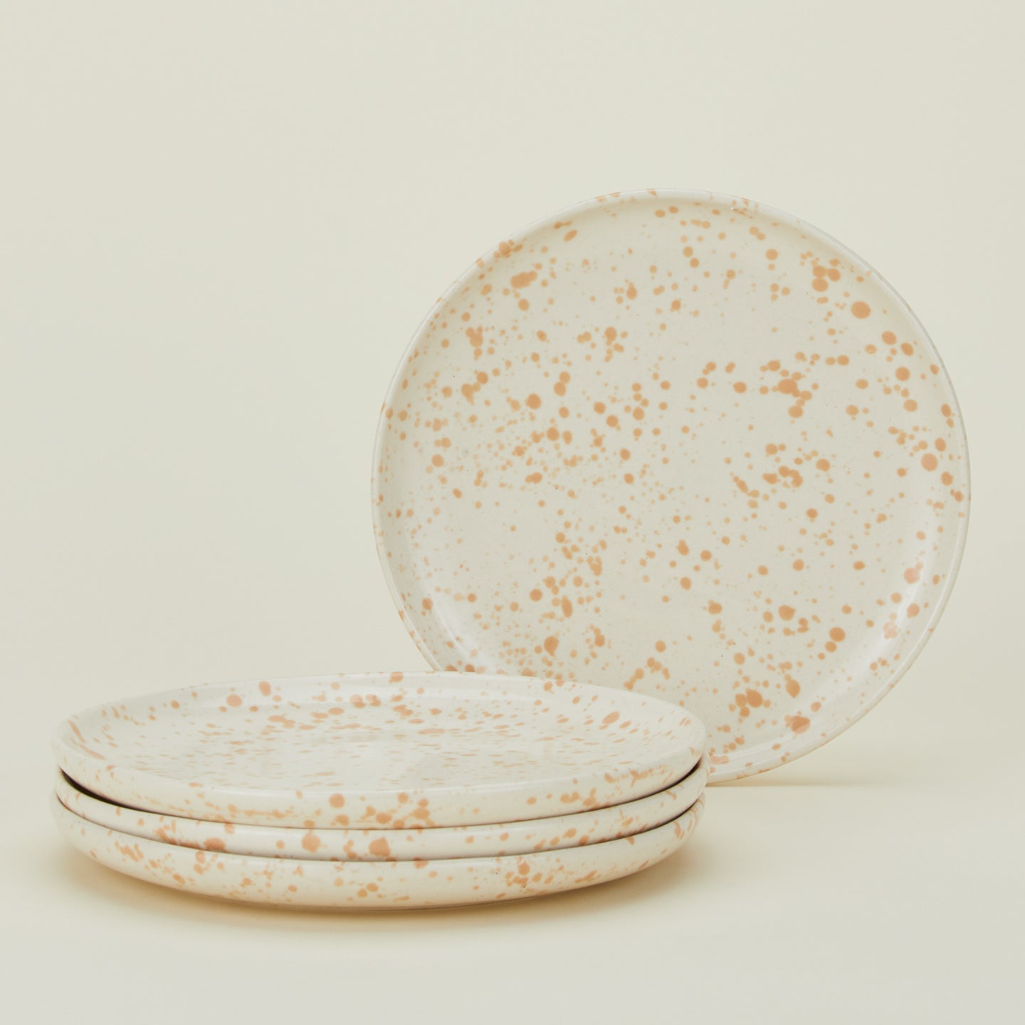 Set of four white plates with latte light brown splatter glaze.