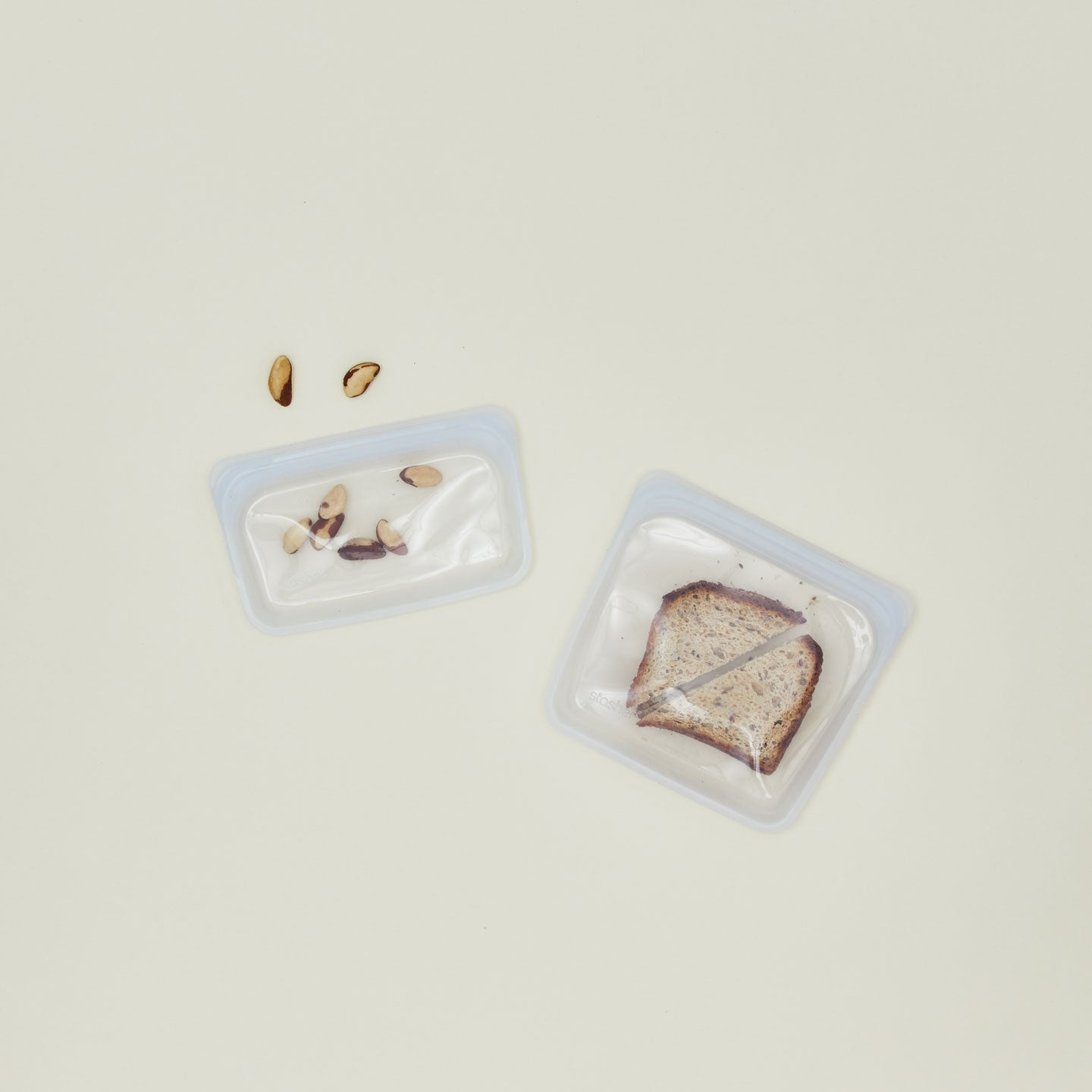 Silicone sandwich bags in two sizes with a sandwich and snacks.