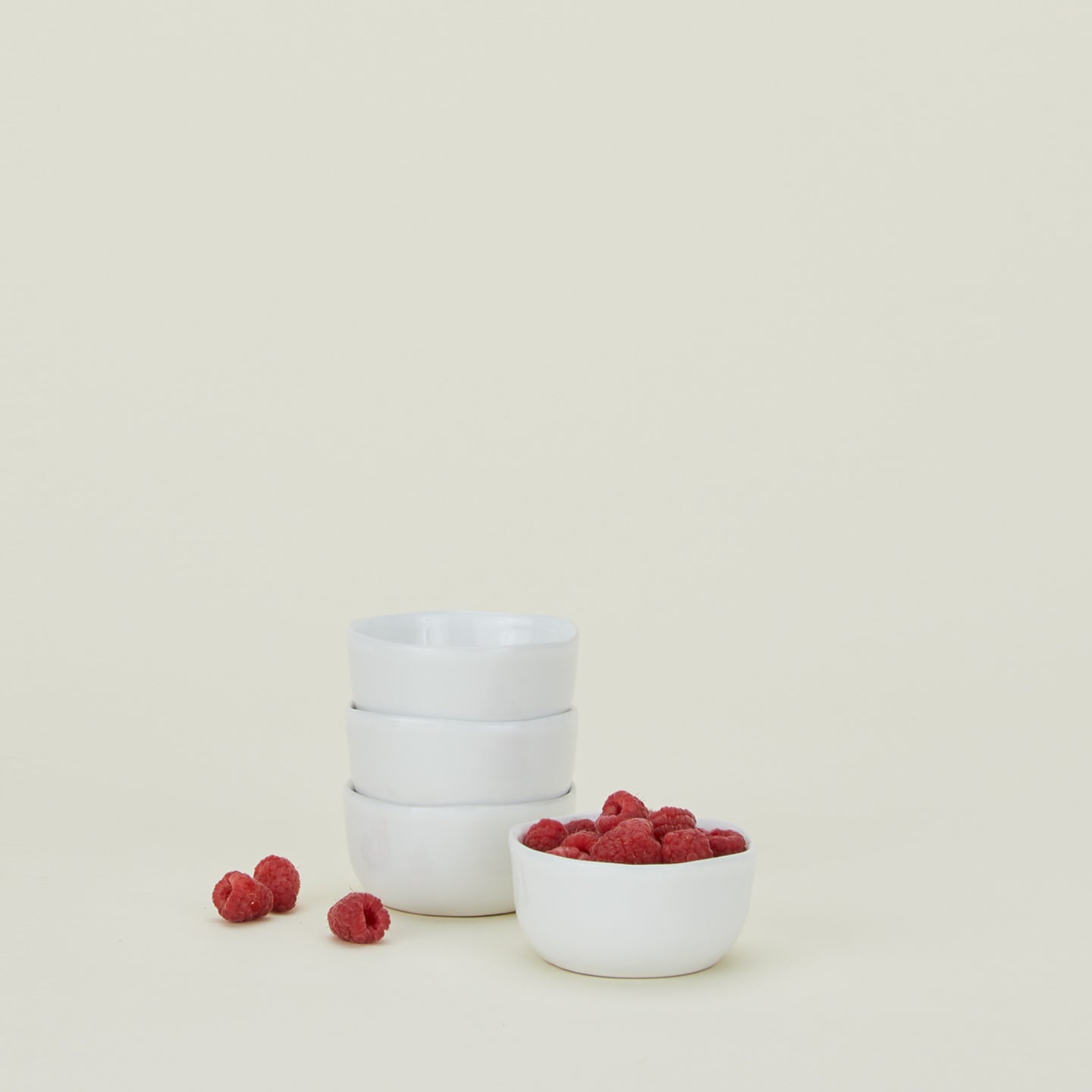 Four white Strata Extra Small Serving Bowls, with raspberries.