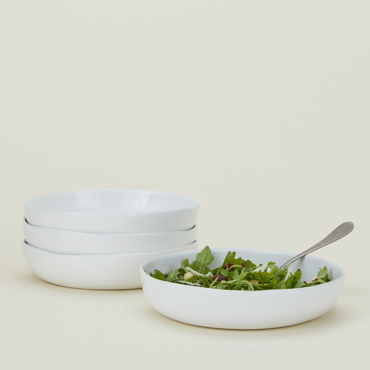 Four white Strata Low Bowls, with salad.