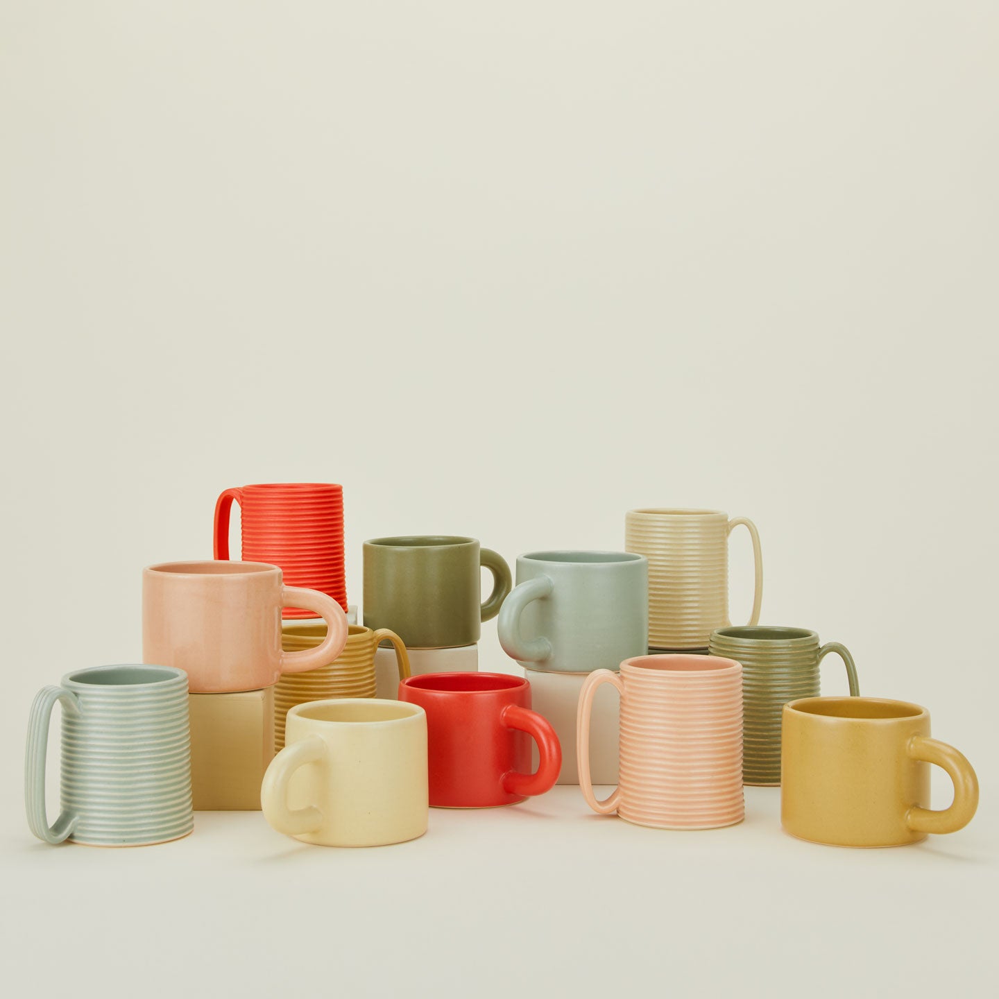 Group of mugs in various colors and sizes.