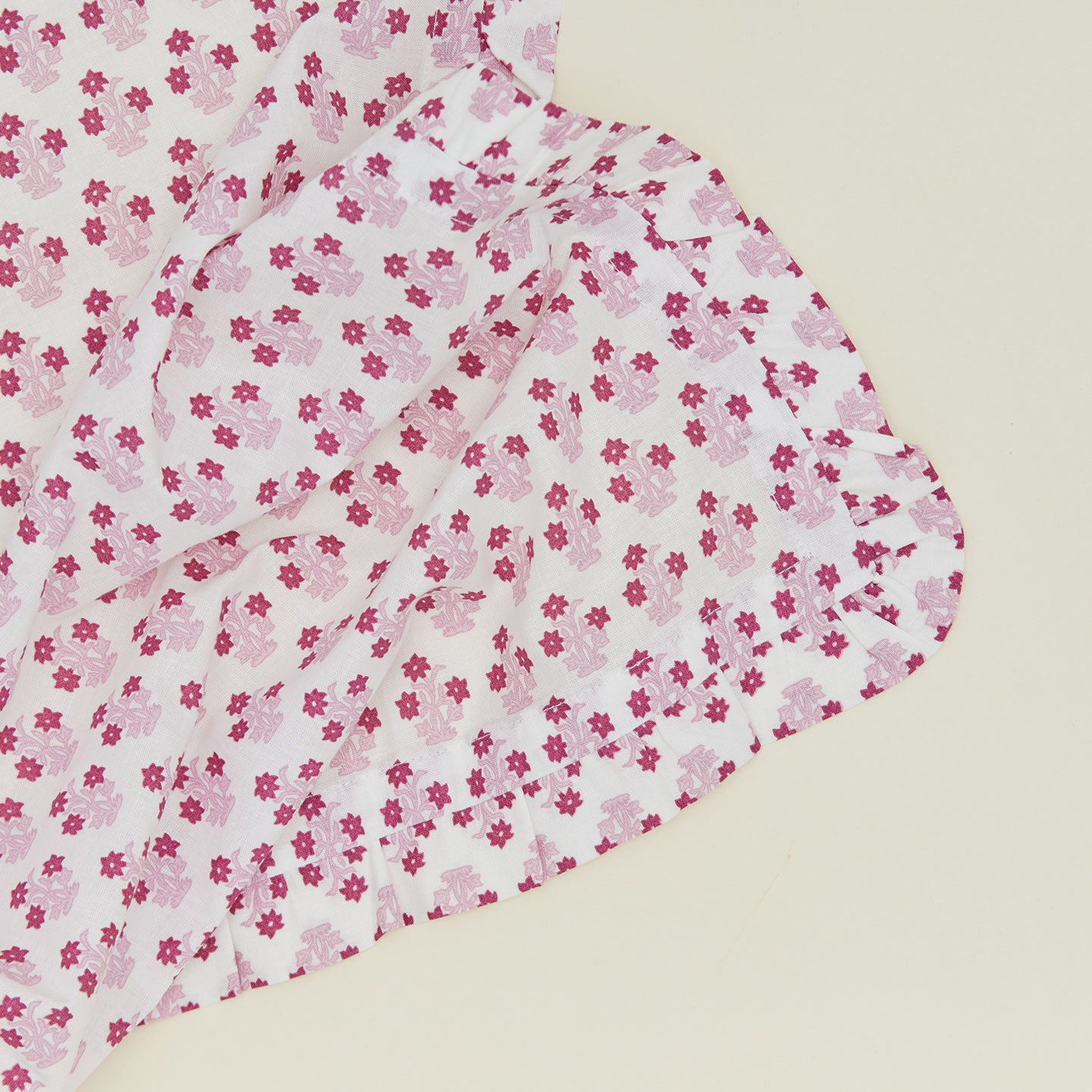 Close up of a ruffled dinner napkin in Abigail pink.